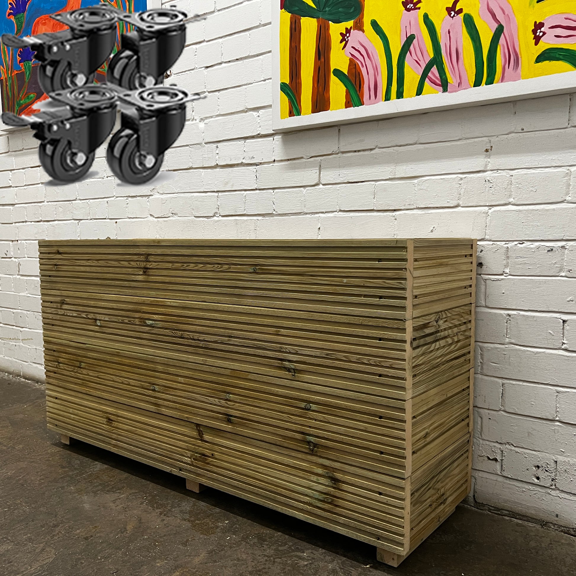 Handmade wooden decking planter with a false bottom, 4ft long and 2ft tall, featuring a set of wheels.